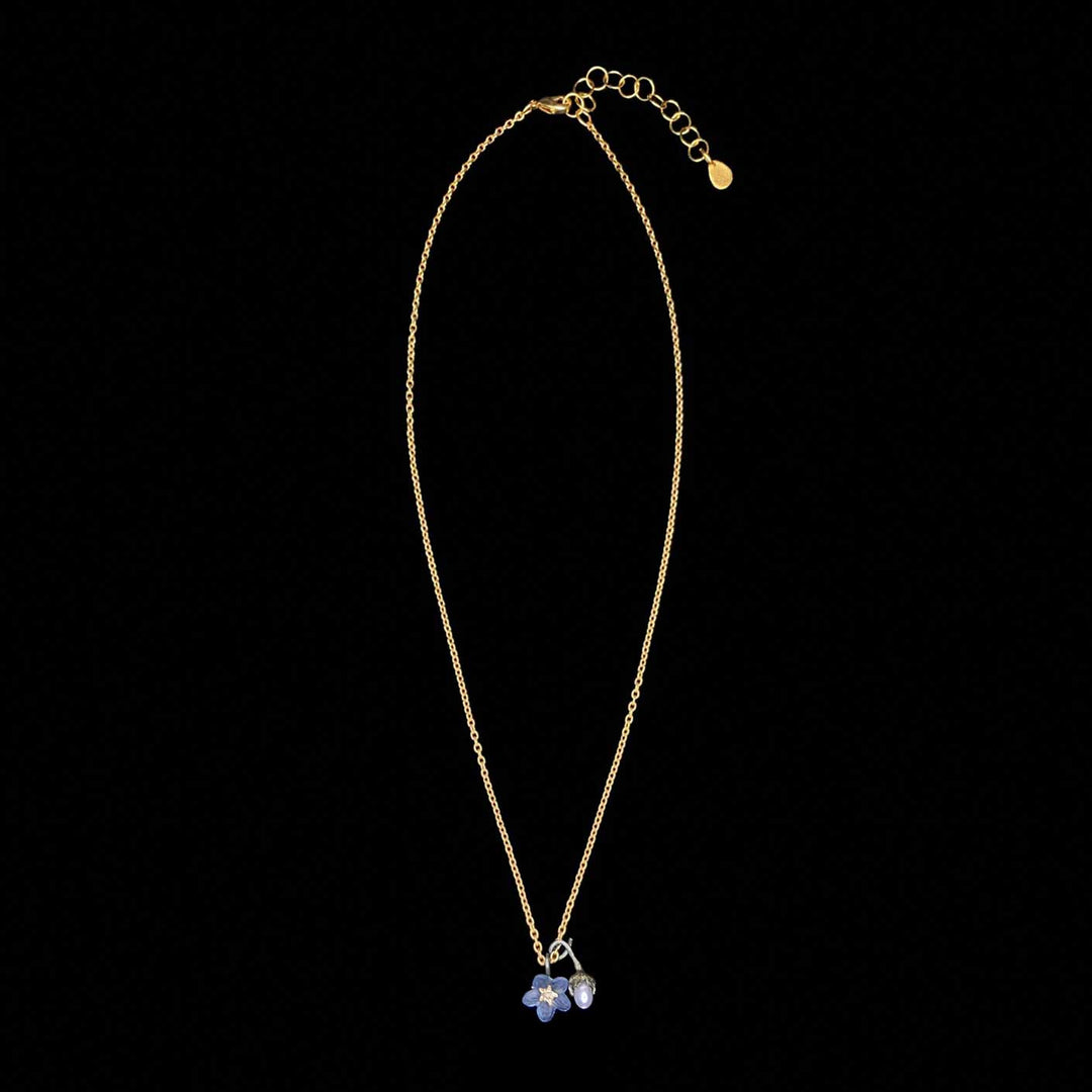 Gold necklace with a floral pendant on a black background