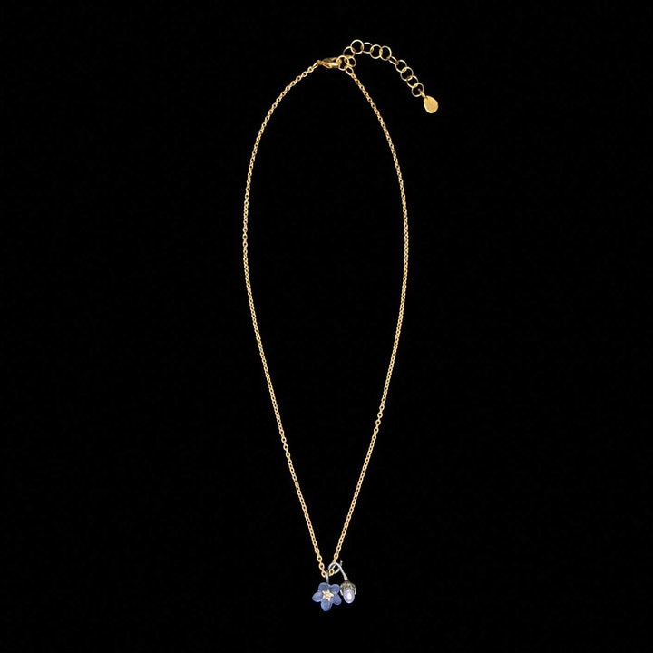 Gold necklace with a floral pendant on a black background