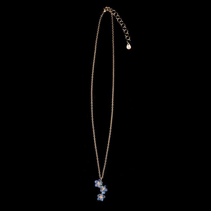 Necklace with a blue flower pendant on a black background