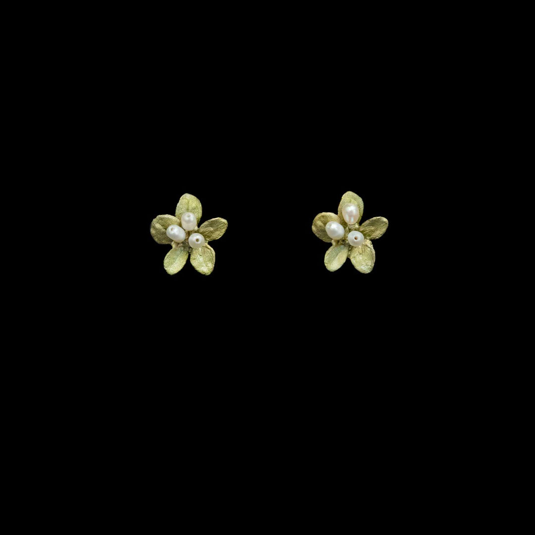 A pair of small flower-shaped stud earrings in textured green with white pearl centers, shown on a solid black background.