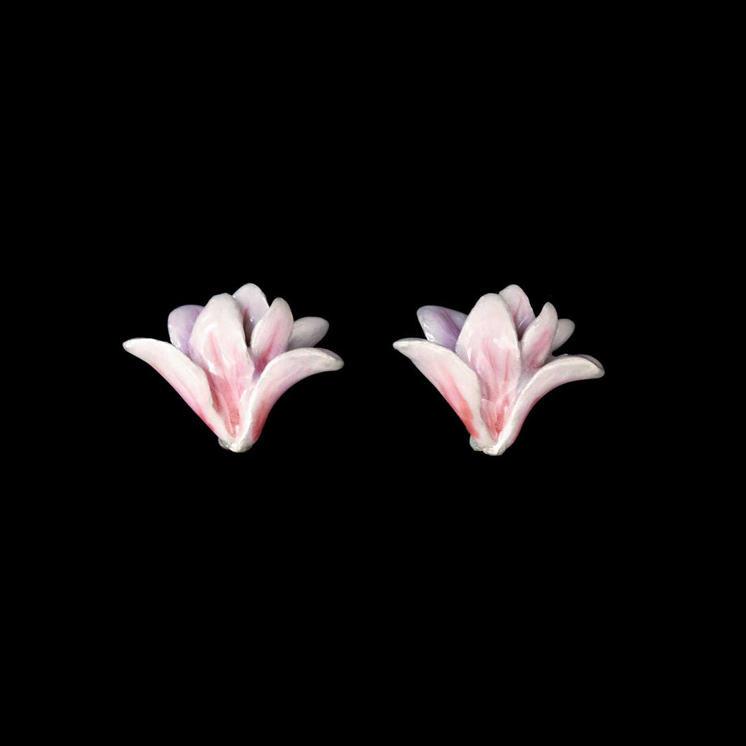 A pair of small flower-shaped stud earrings with pale pink petals and subtle lavender undertones, shown on a solid black background.