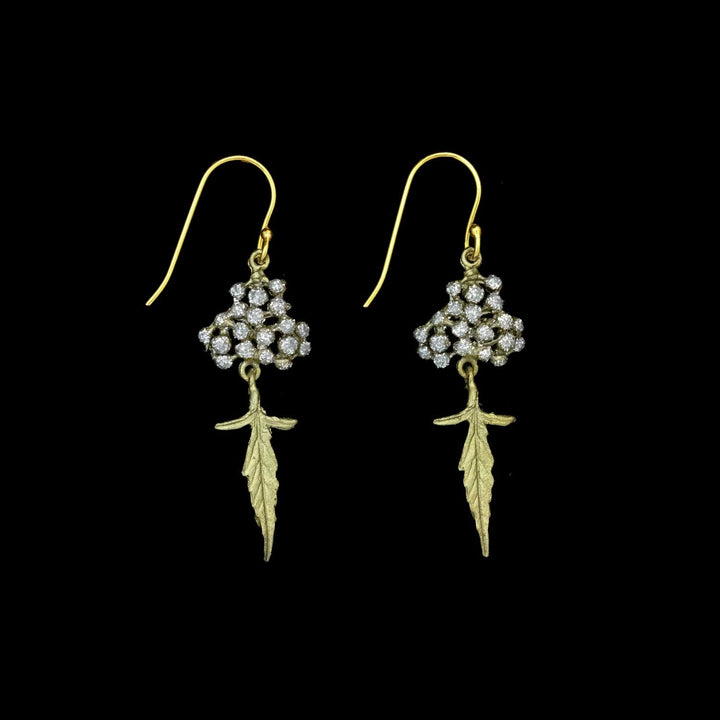 Pair of green leaf and crystal dust dotted earrings on a black background