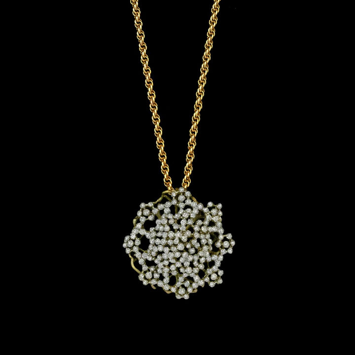 Gold necklace with a intricate pendant on a black background
