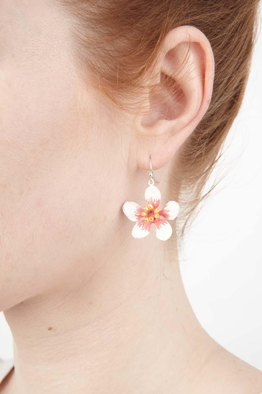 The Almond Blossom earrings are cast in hand patinated bronze with flowers featuring a matte white silver finish over bronze with yellow rice pearls. The wires are 925 Sterling Silver.