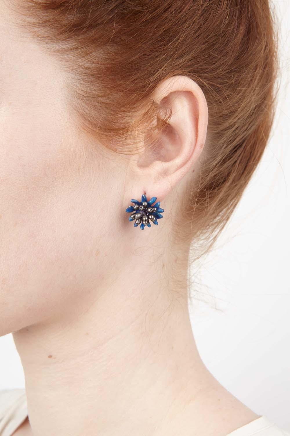 The Blue Cornflower earrings are cast in bronze with blue enamel and peacock freshwater pearls.